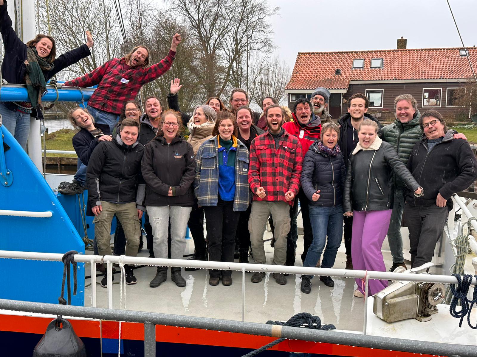 Het team SailWse 2023 staat enthousiast op de catamaran Beatrix